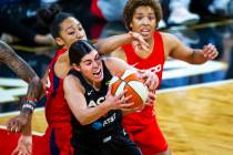 Las Vegas Aces guard Kelsey Plum (10, center) secures a loose ball over Washington Mystics forw ...