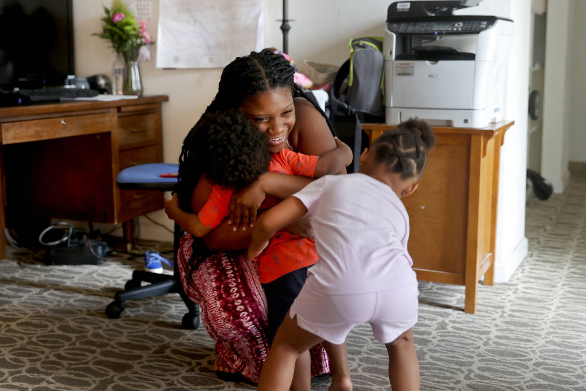 Tytaliayah Parker gets a hug from one of her five unidentified foster siblings and her biologic ...