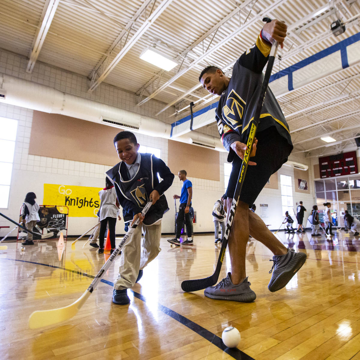 Eight-year-old Desmond Hester, left, plays with Golden Knights forward Ryan Reaves during a you ...