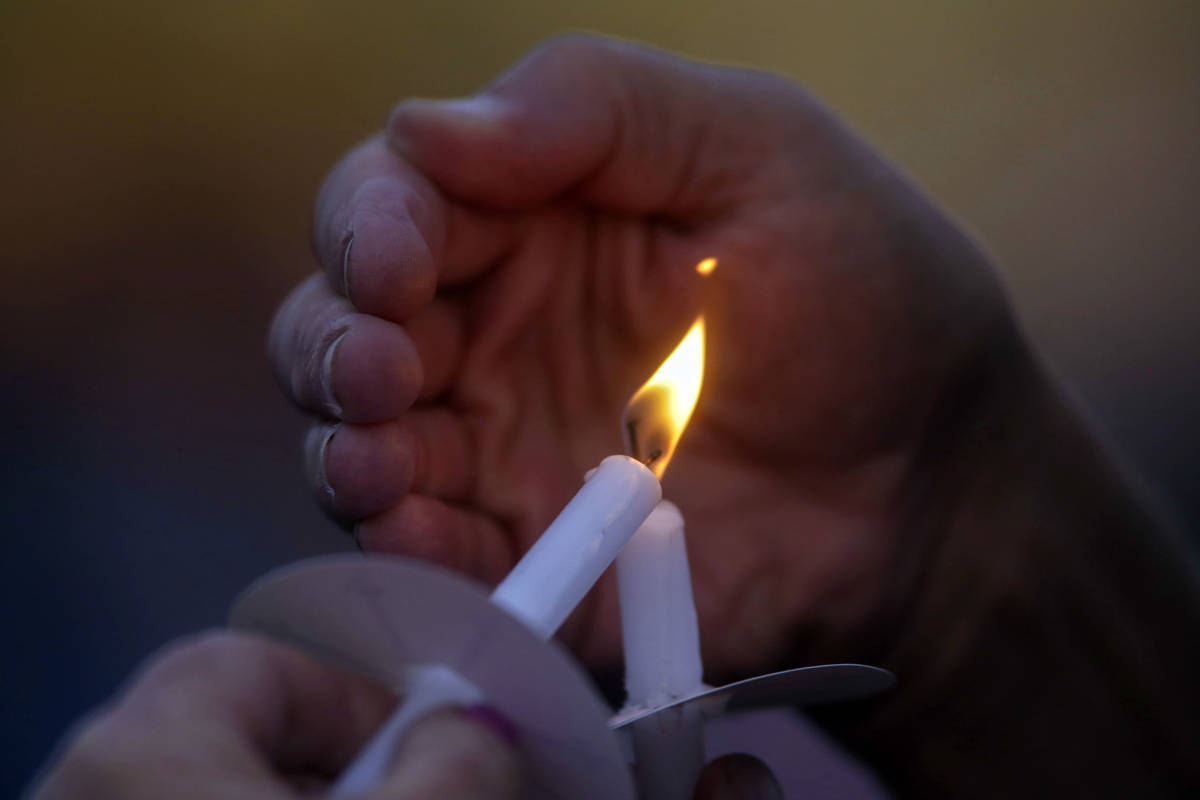 Visitors light their candles during a memorial service for Tylee Ryan and Joshua “JJ&#x2 ...