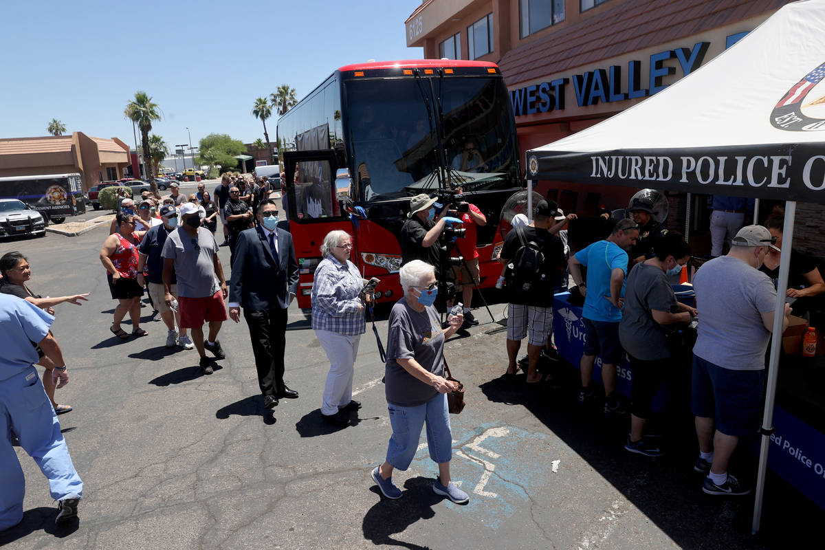 People line up to T-shirts during a fundraiser for Las Vegas police officer Shay Mikalonis at S ...