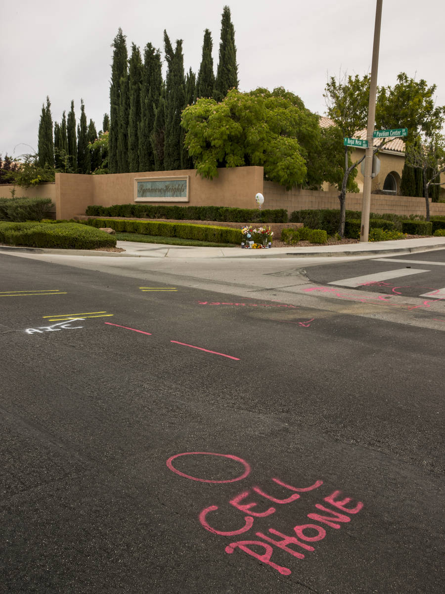 Police spray paint outlines a cell phone spot on the road mark where two teen brothers were kil ...