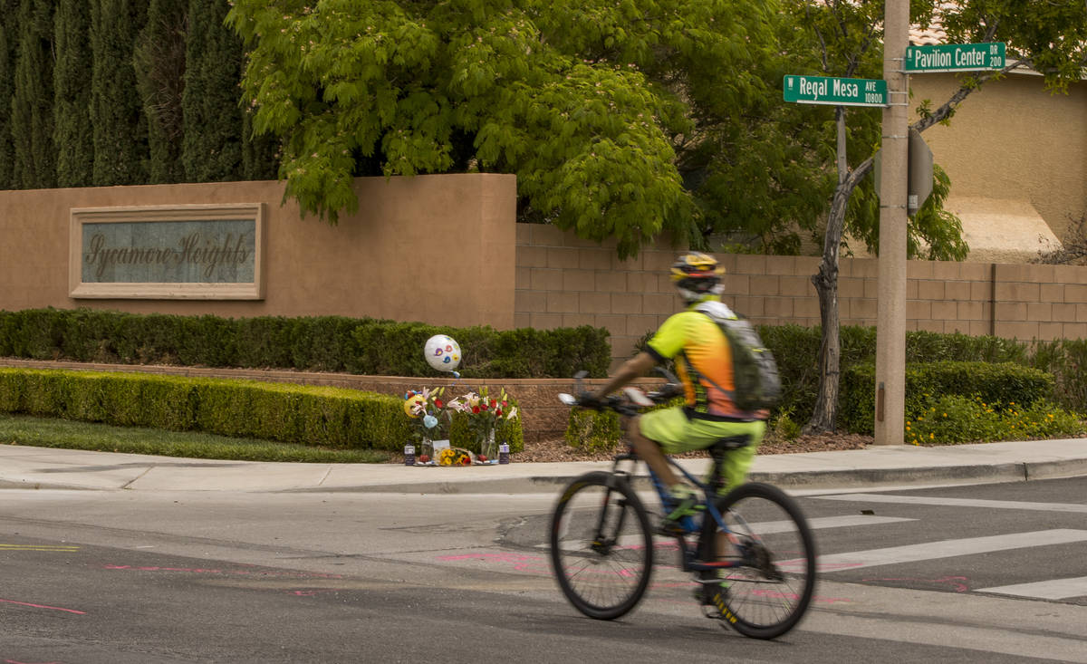 A cyclist looks to a small memorial near where two teen brothers were killed in a recent motorc ...