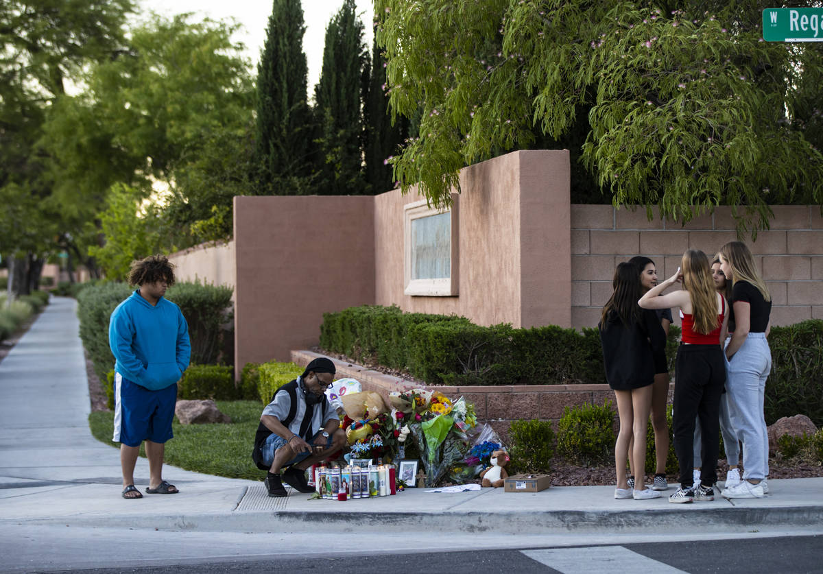 Mel E., second from left, lights candles as people gather for a vigil in memory of David Cox, 1 ...