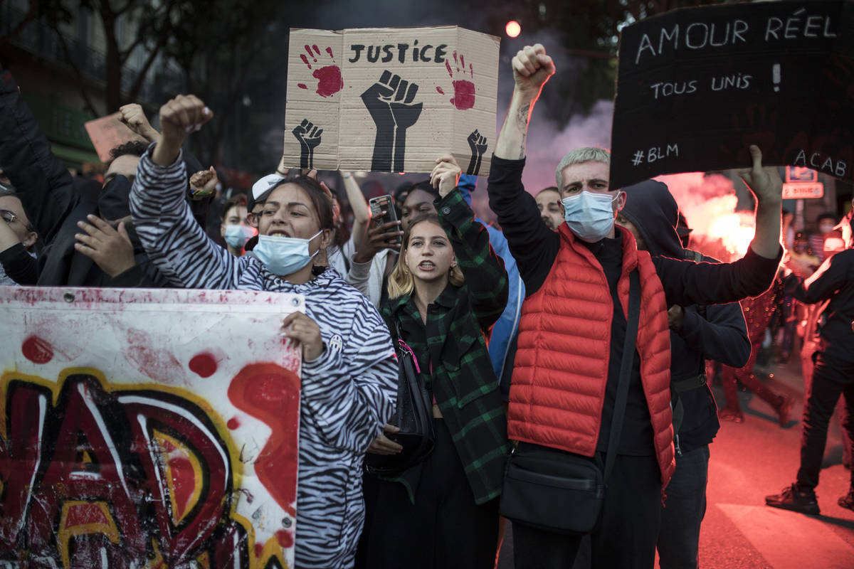 Protesters raise their fists during a march against police brutality and racism in Marseille, F ...