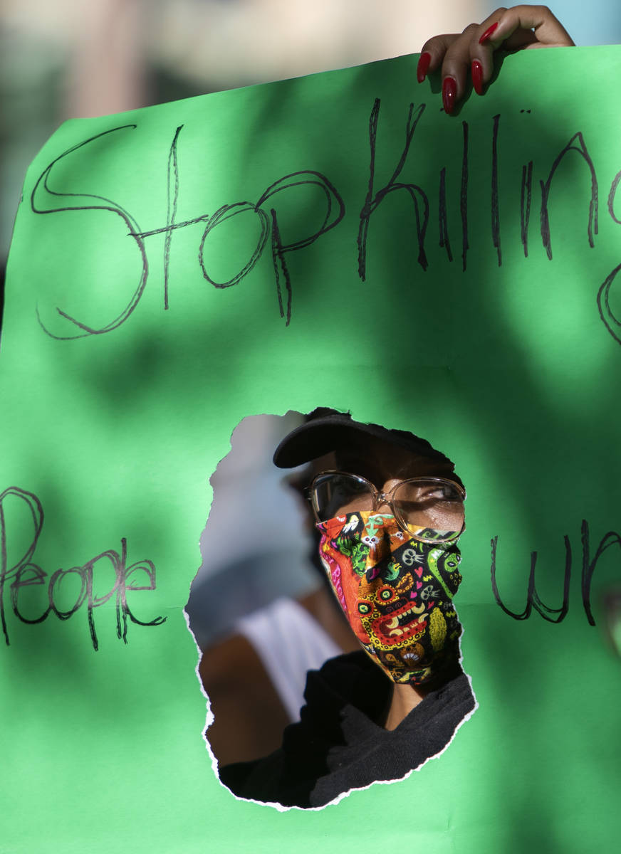 One protester holds a sign reading "Stop killing people who look like me" as the prot ...