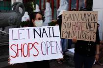 FILE - In this June 8, 2020, file photo nail salon workers hold signs during a protest in Westm ...