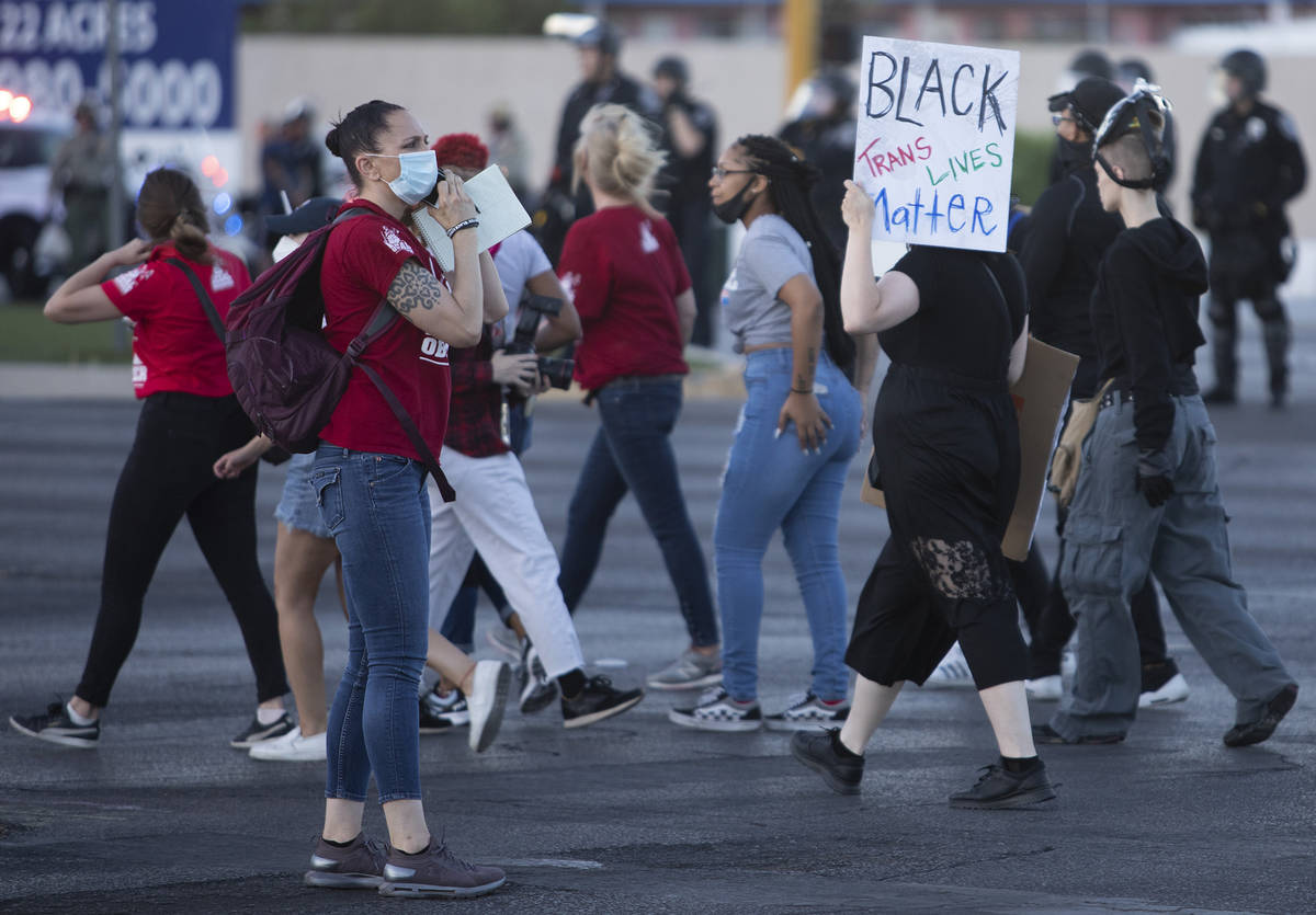One legal observer makes a phone call during a protest against police brutality on Saturday, Ju ...