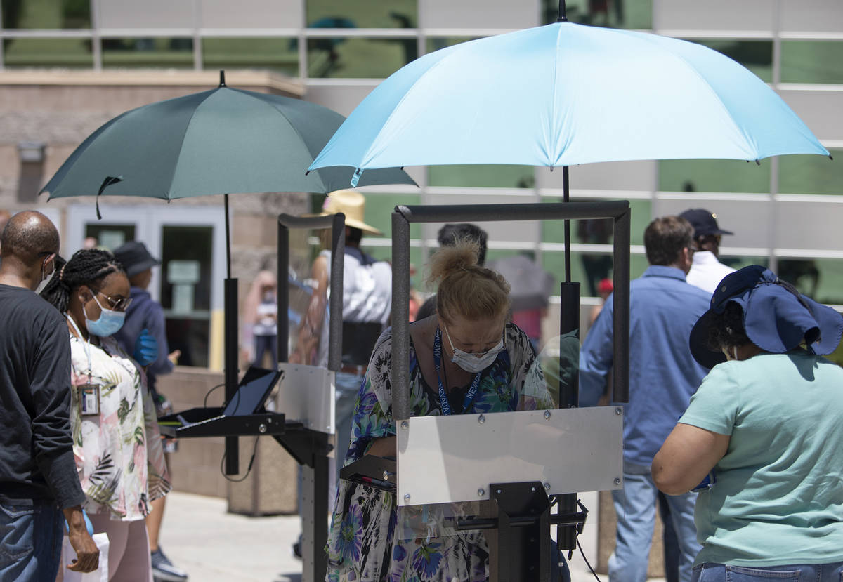 A shield to prevent coronavirus spread is between employees and customers at the Nevada Departm ...
