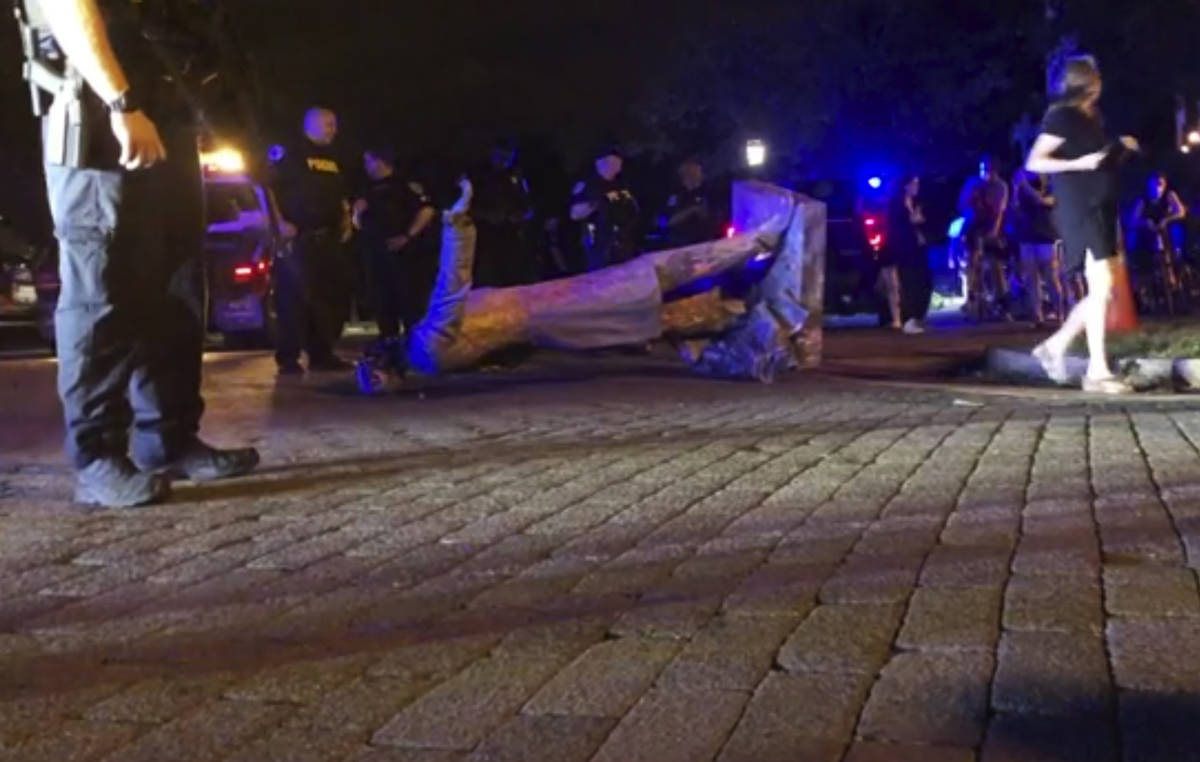 Police stand near a toppled statue of Jefferson Davis on Wednesday night, June 10, 2020, in Ric ...