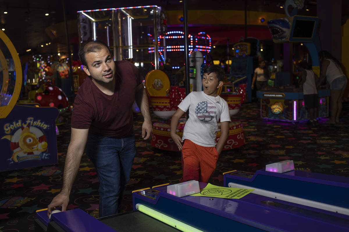 Daniel Contreras and his son Damian Contreras, 7, play Skee-Ball at John's Incredible Pizza on ...