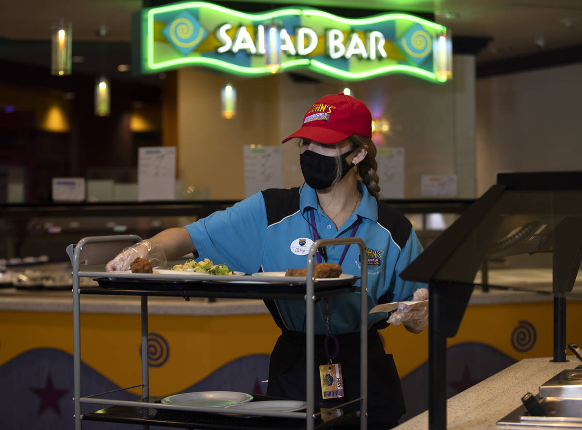 Abigail Gonzalez loads a cart with a table's order from the buffet at John's Incredible Pizza o ...