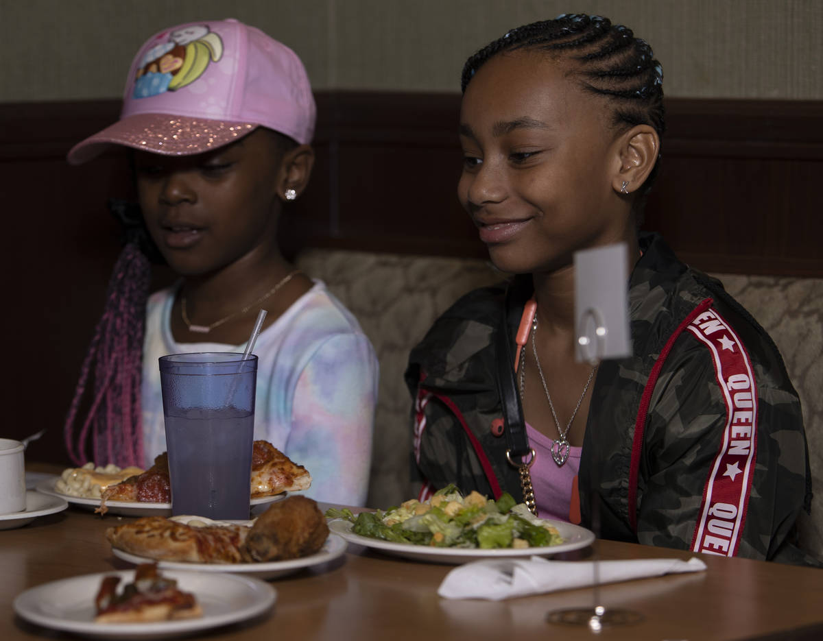 Khristian Walker, 7, left, and Kammi Walker, 10, right, smile as their food arrives from the bu ...