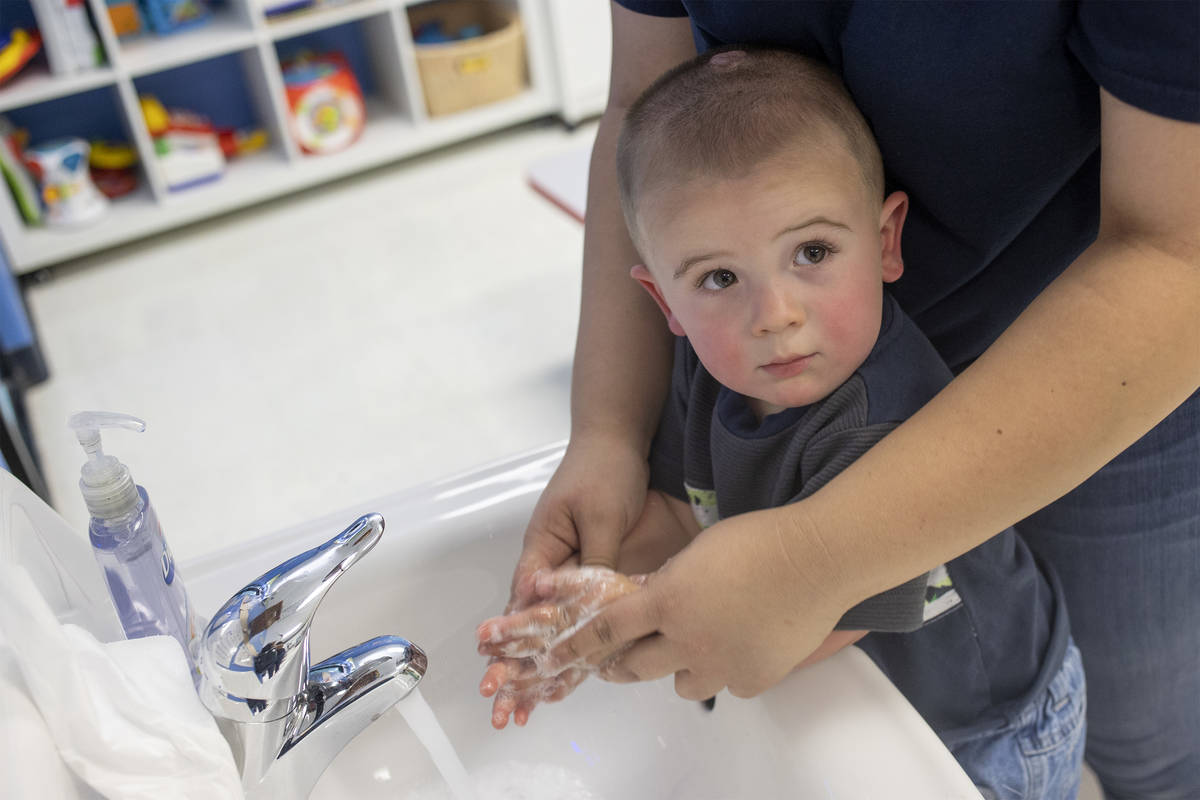 Memphis washes his hands after playing outside at Rising Star Preschool & Childcare on Mond ...