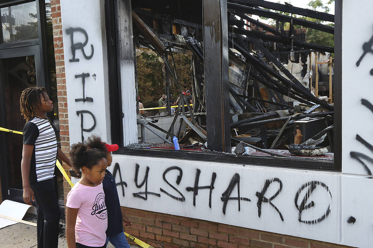 Children take in the burned Wendy's location in Atlanta on Monday, June 15, 2020, outside which ...