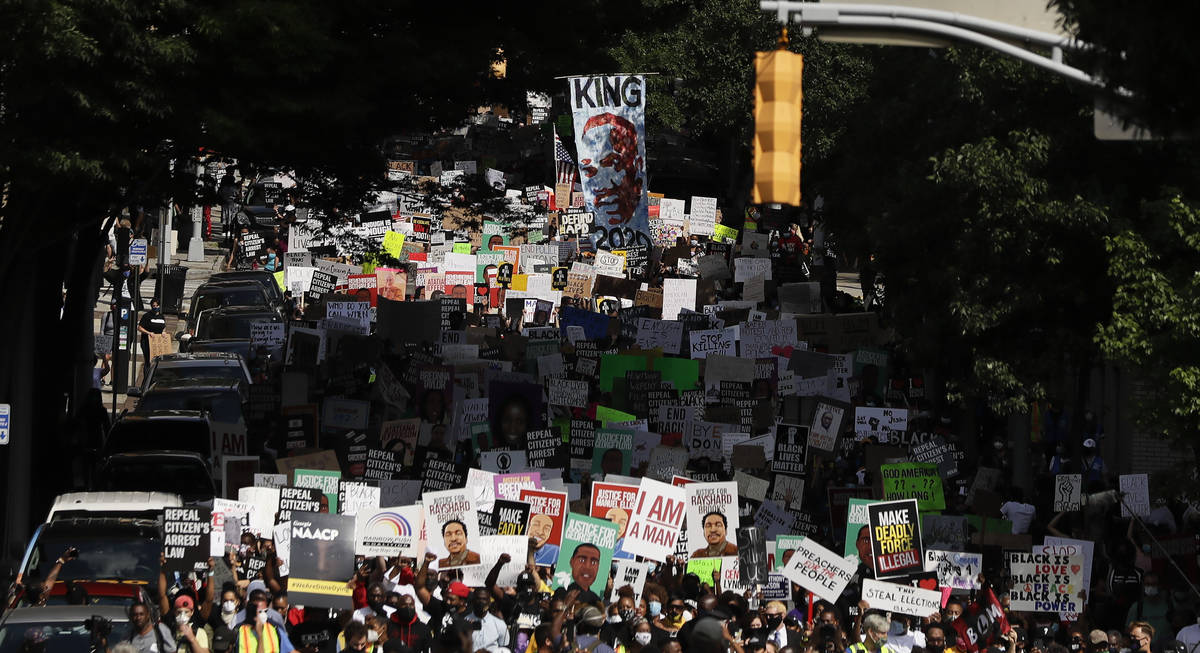 People march down the street towards the Georgia state capitol to protest against the mistreatm ...