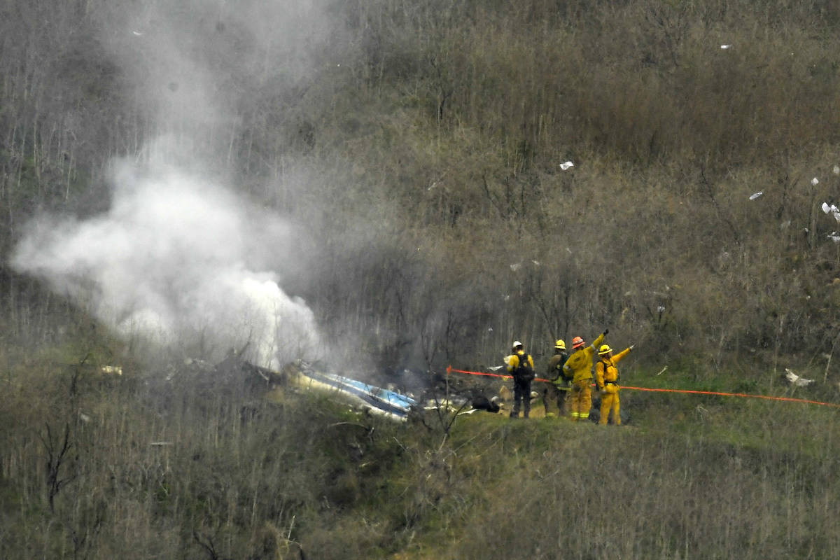 FILE - In this Jan. 26, 2020, file photo, firefighters work the scene of a helicopter crash whe ...