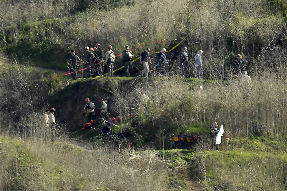 FILE - In this Jan. 27, 2020, file photo, investigators work the scene of a helicopter crash th ...