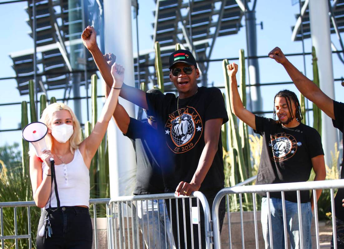 Kayla Cervantes, left, alongside Minister Vance ÒStretchÓ Sanders, raise their fists ...