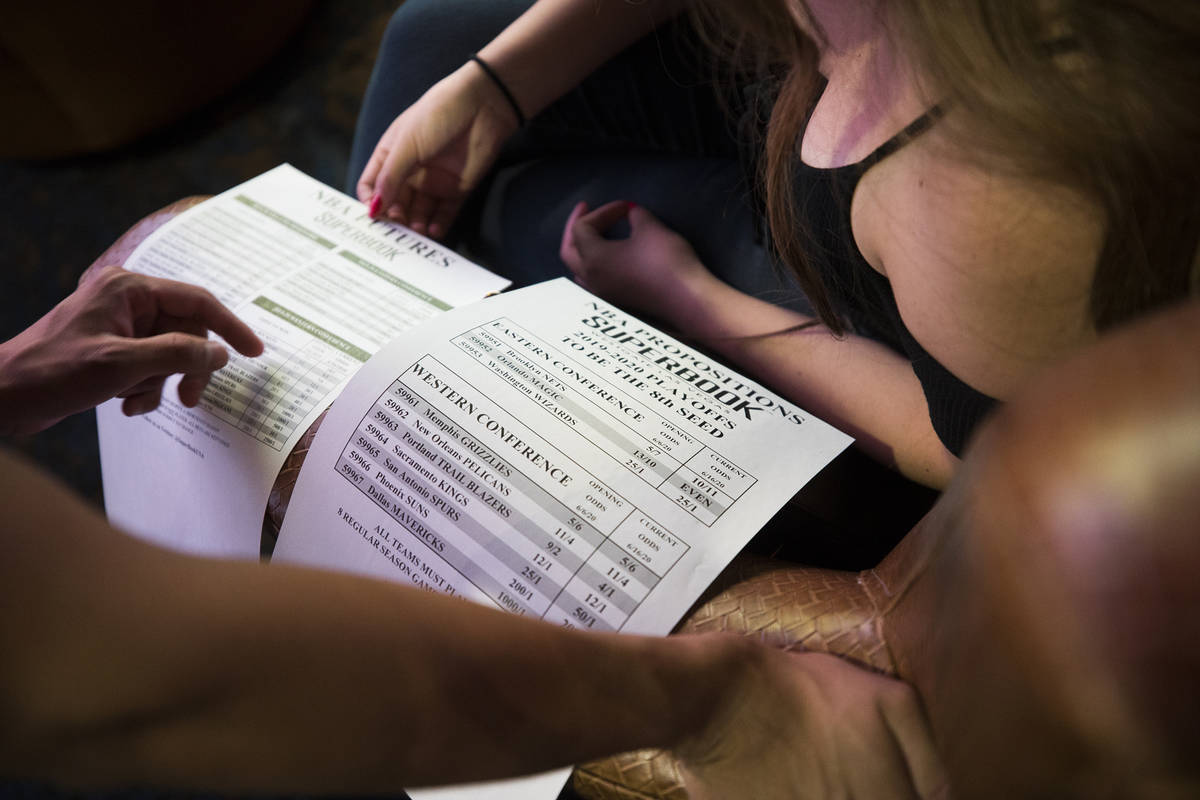 Irene Rodriguez, right decides on what to bet with her boyfriend Reuben Gutierrez, left, at the ...