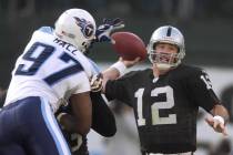 Raiders' quarterback Rich Gannon (12) prepares to throw in the first quarter as Titans' Carlos ...