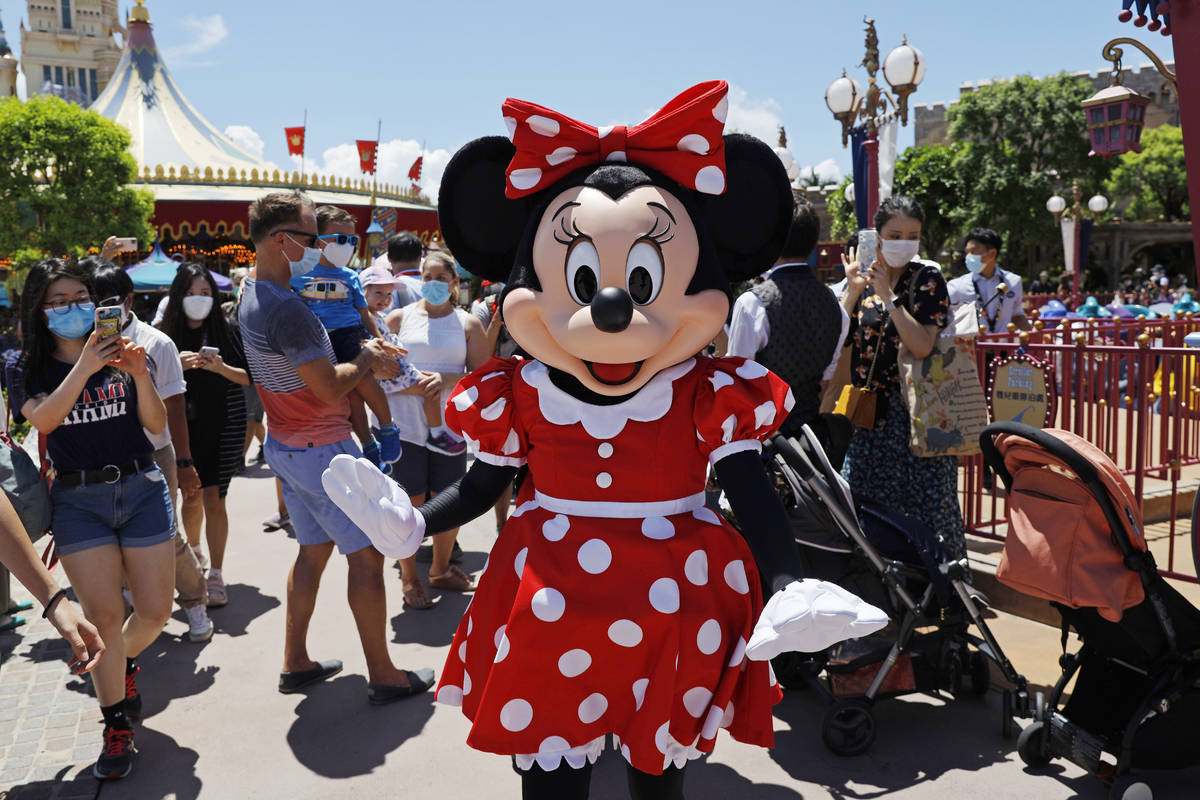 The iconic cartoon character Minnie Mouse waves to visitors at the Hong Kong Disneyland on Thur ...