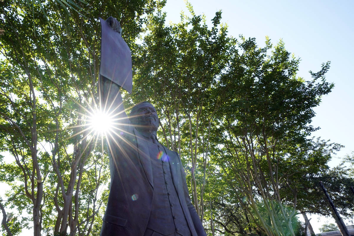 This statue depicts a man holding the state law that made Juneteenth a state holiday in Galvest ...