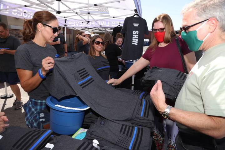 Shelly Hudson, left, shows shirts to Carrie Zeidman and her husband, Bob, of Las Vegas, during ...