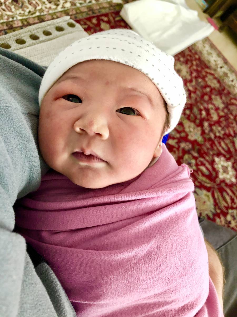 Newborn Sadie Stein looks up at her parents at her home in Madrid, Spain. Her parents, Sarah an ...