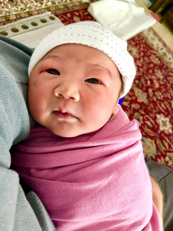 Newborn Sadie Stein looks up at her parents at her home in Madrid, Spain. Her parents, Sarah an ...