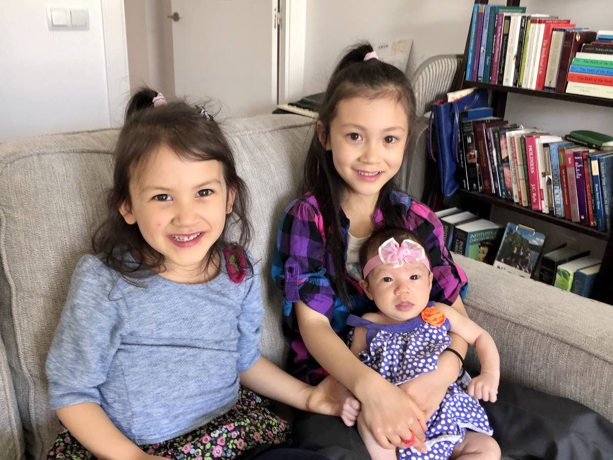 (From left to right) Lorelai Stein, 7, and Audrey Stein, 4, hold their newborn sister, Sadie, i ...