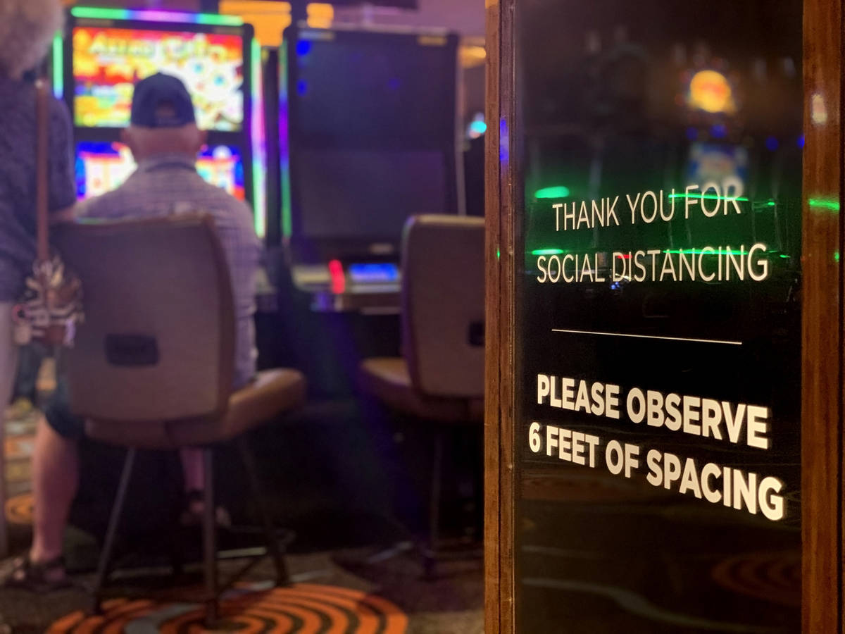 A sign calling for social distancing is seen as individuals play games at Gila River Casino at ...
