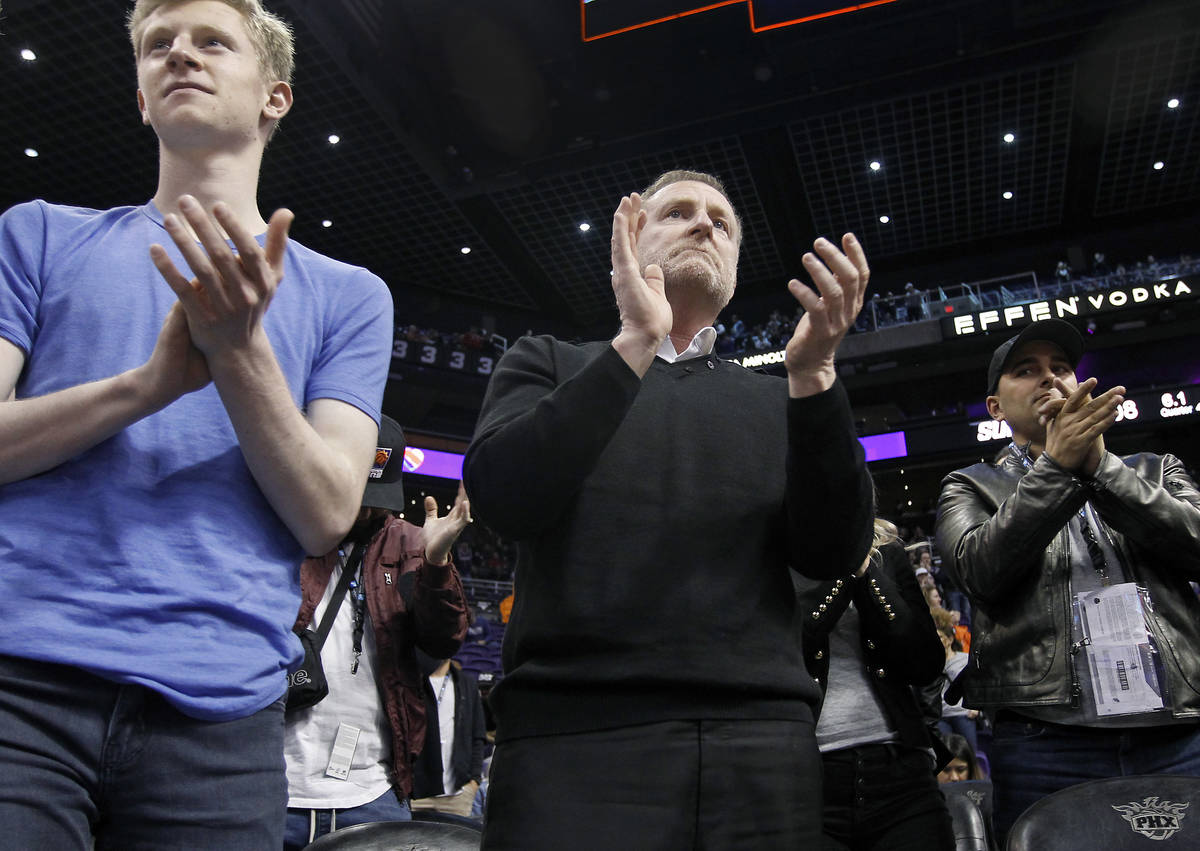 Phoenix Suns owner Robert Sarver, center, applauds the teams 107-99 victory against the Minneso ...
