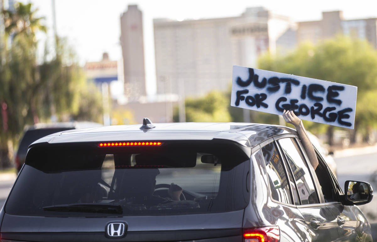 Protesters hold signs out of cars on Sahara Avenue during a Juneteenth rally organized by Black ...