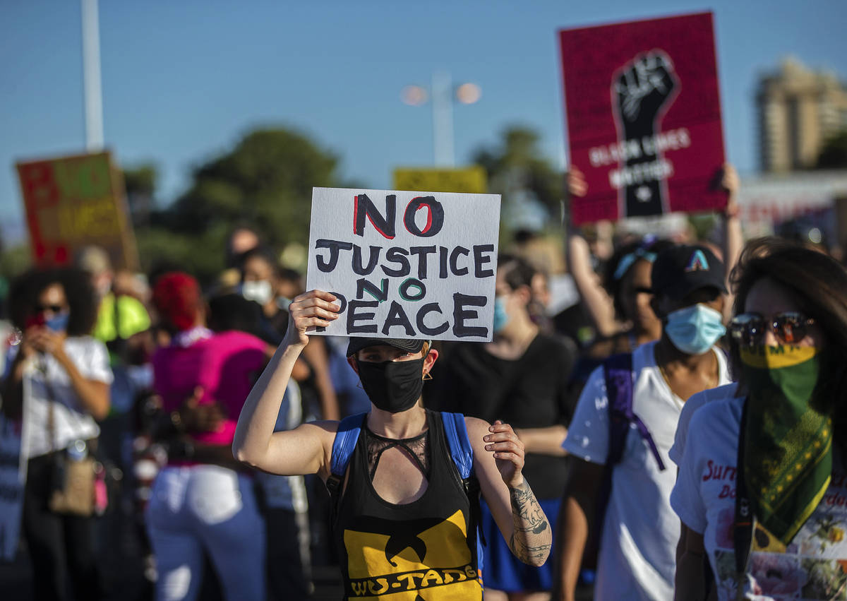 Protesters march on Sahara Avenue during a Juneteenth rally organized by Black Lives Matter on ...