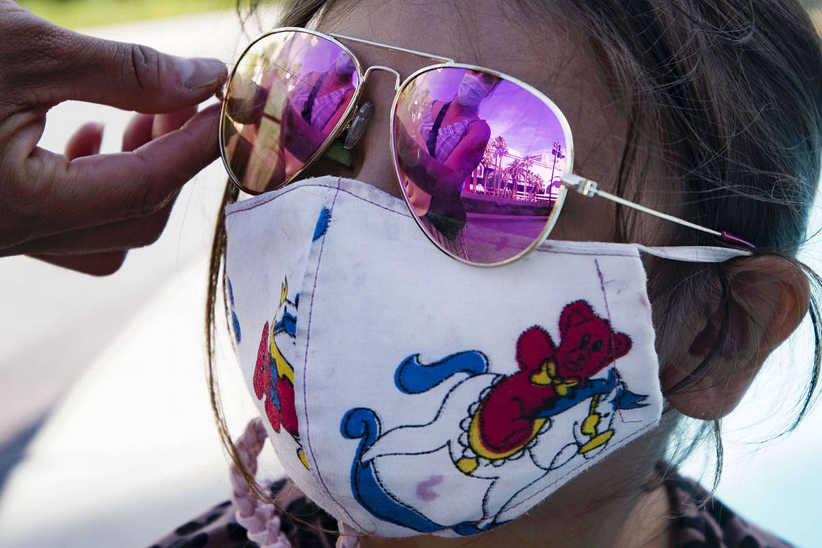 Jannete Gurrola, of Los Angeles, adjusts the sunglasses on her daughter Nadia Saucedo, 4, outsi ...