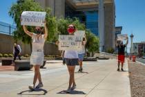 A small group walks with signs as part of a Black Lives Matter rally outside the Lloyd D. Georg ...