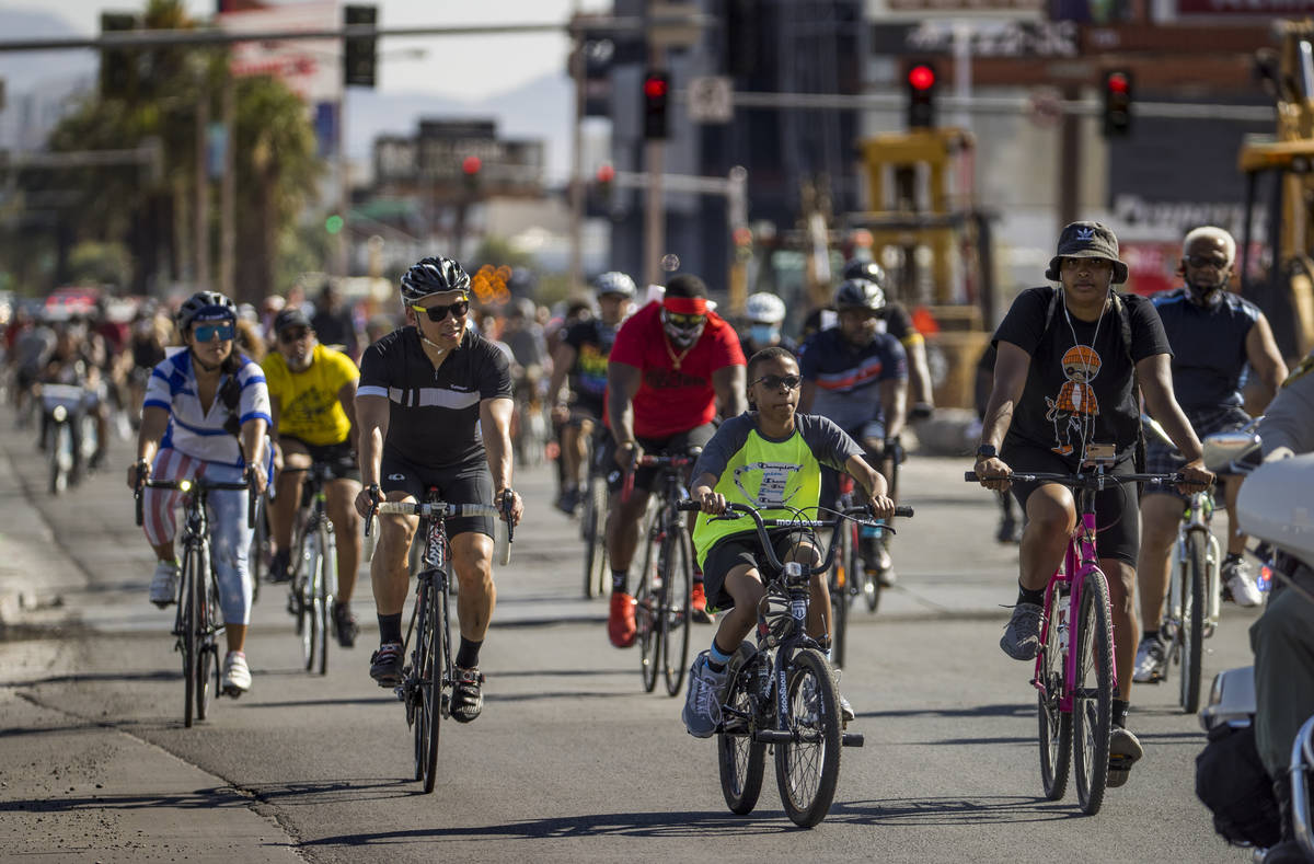 Participants in a Black Lives Matter bike ride against injustice pass by the Resort's World con ...
