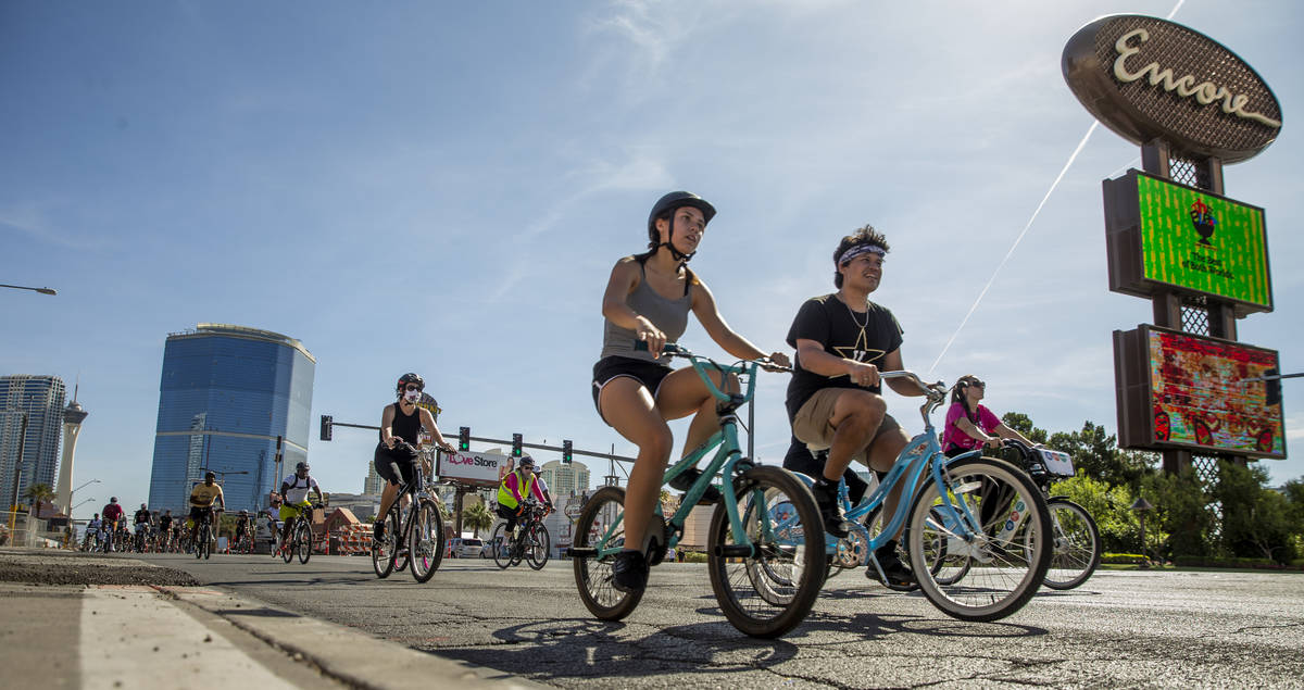 Participants in a Black Lives Matter bike ride against injustice pass by the Resort's World con ...