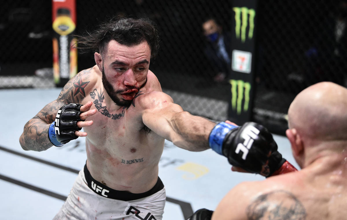 LAS VEGAS, NEVADA - JUNE 20: (L-R) Shane Burgos punches Josh Emmett in their feathweight bout d ...