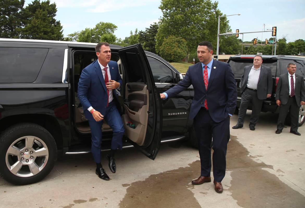 Gov. Kevin Stitt, left, arrives at the Cox Business Center in downtown Tulsa, Okla., ahead of a ...