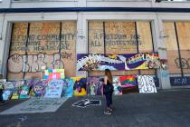 Plywood and artwork cover a wall on a closed police precinct Thursday, June 18, 2020, in Seattl ...