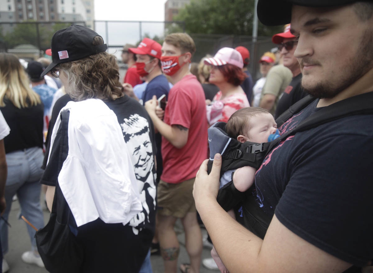 Jacob Osborne and his son Phoenix, enter as safety barricade gates are opened for supporters to ...