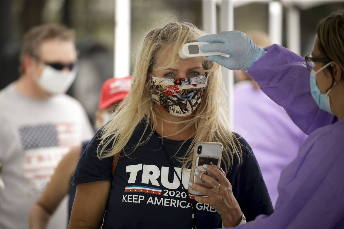 A supporter gets her temperature checked prior to attending a campaign rally for President Trum ...