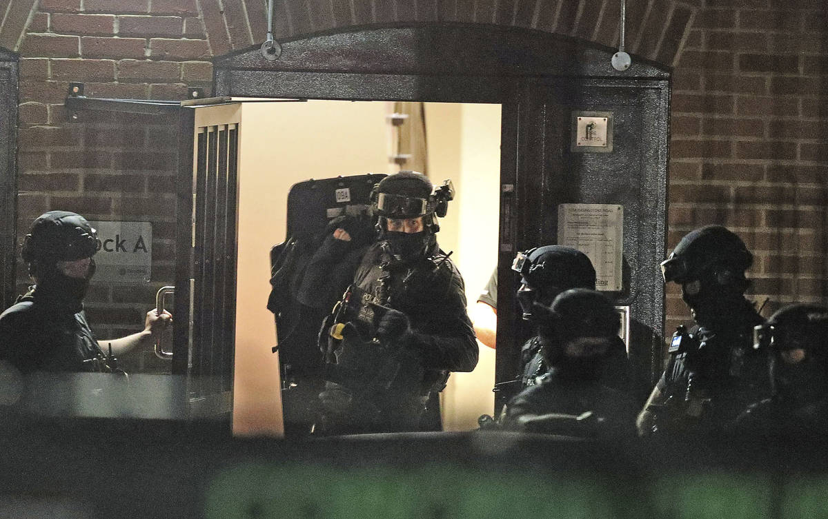 Armed police officers work at a block of flats off Basingstoke Road in Reading after an inciden ...