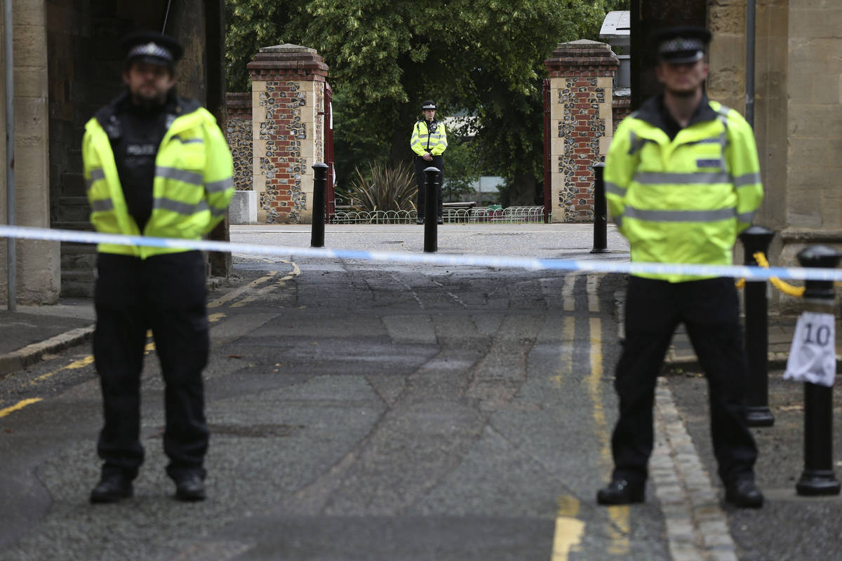 Police stand guard at the Abbey gateway of Forbury Gardens park in Reading town centre followin ...