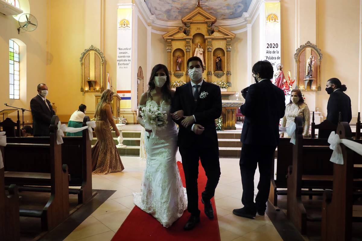 Bride Jazmin Sanabria and her groom Joel Adorno, wearing protective face masks amid the new cor ...