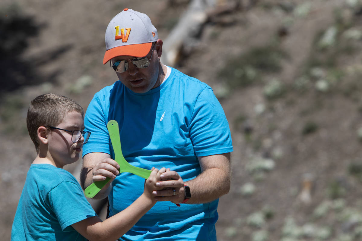 Jeff Whitehead teaches his son, Garrett Whitehead, 8, how to throw a boomerang at Lee Canyon on ...