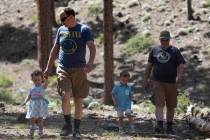 Thomas Doyle, left, walks his daughter, Mia Doyle, 2, back to their campsite as his brother, Jo ...