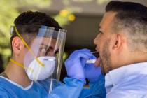 Nevada National Guard soldier PFC Nikolas Herrera, left, inserts a swab into the mouth of Paulo ...